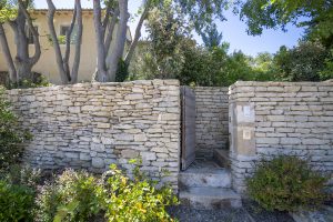 Entrée du Mas Paillan avec un mur en pierre